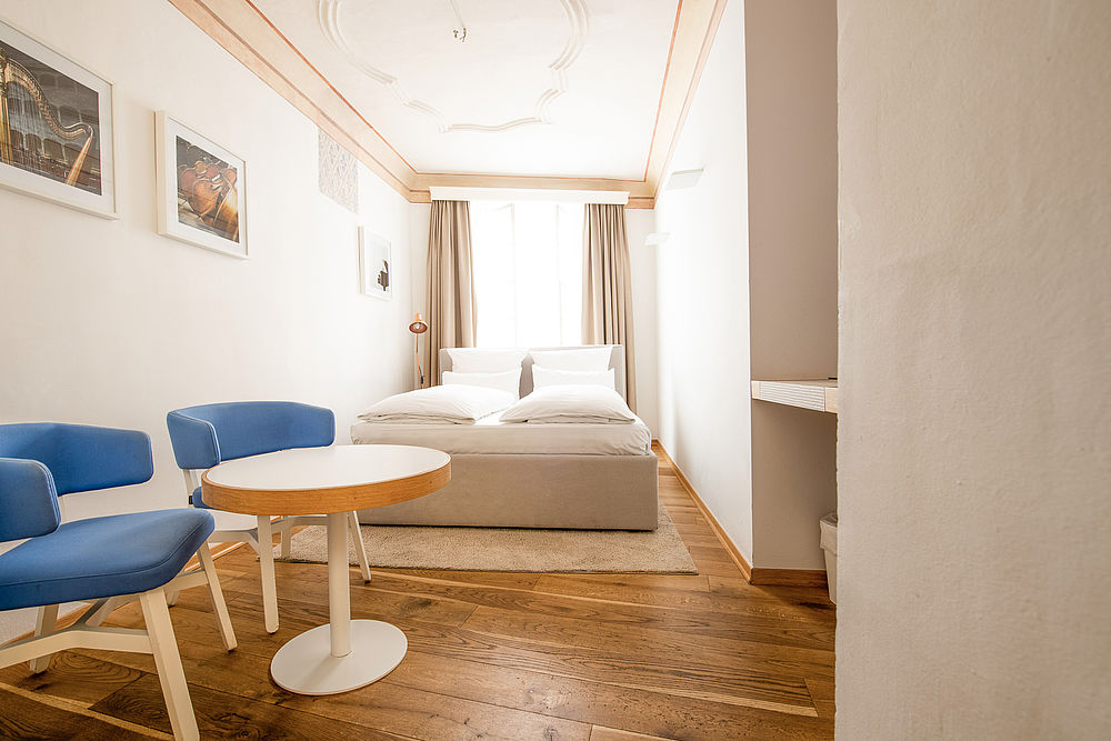 Länglich gezogenes Schlafzimmer mit gemütlichen Doppelbett im Boutique Hotel Goldgasse