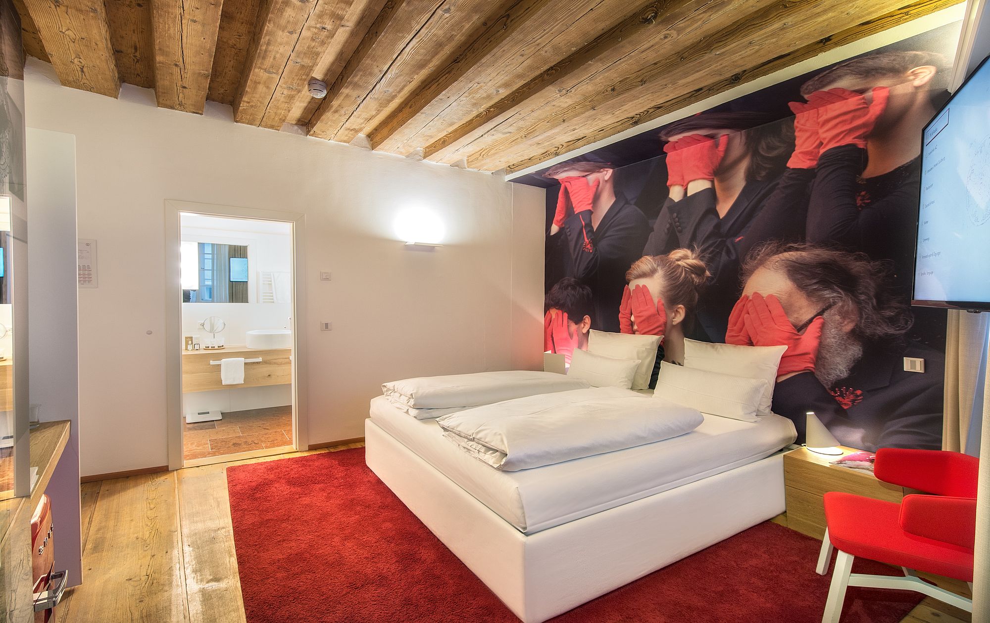 Doppelbett mit Wandtapete und angrenzenden Bad im romantischen Hotel Salzburg