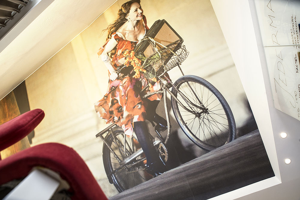 Großes Foto einer Frau auf ihrem Fahrrad im Boutique Hotel Goldgasse