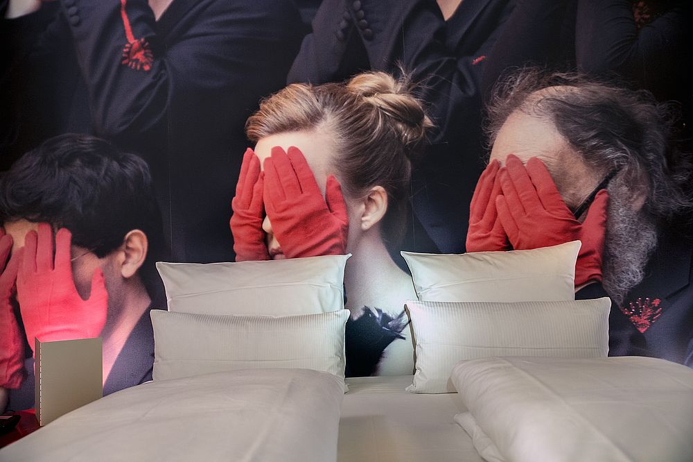 Fototapete mit schwarz gekleideten Personen mit roten Handschuhen im Boutique Hotel Salzburg