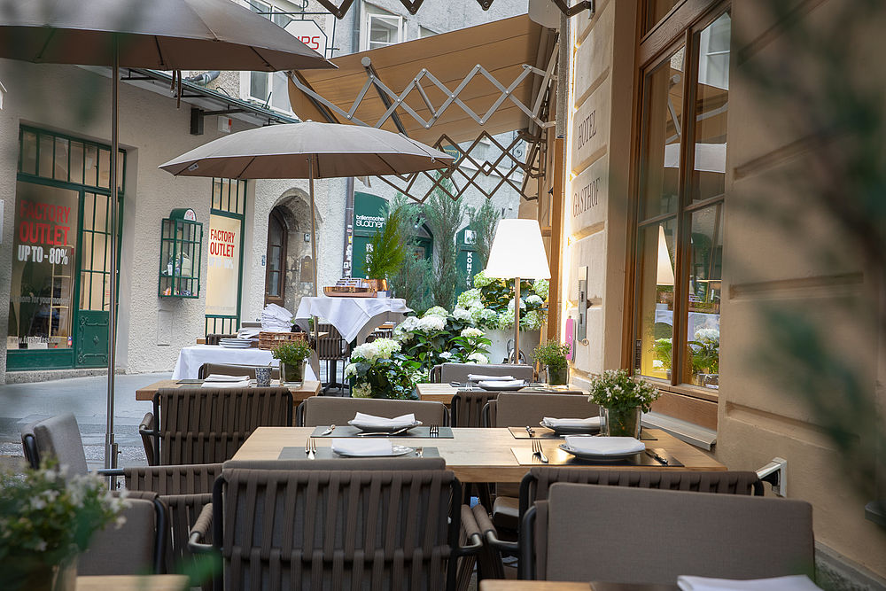Tische im Freien für ein Frühstück in Salzburg im Gasthof Goldgasse