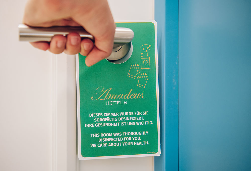 Desinfektionsschild an einer Türklinke des Boutique Hotel Salzburg für den Gast