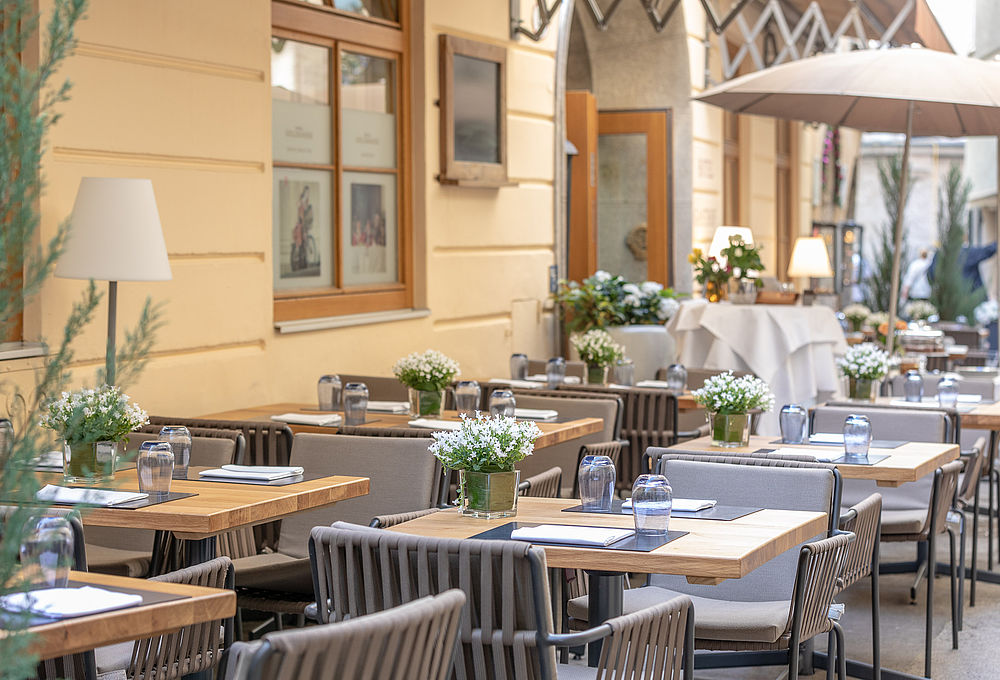 Viele Tische und Stühle im Außenbereich des Gasthof Goldgasse bei einem Kurzurlaub in Salzburg