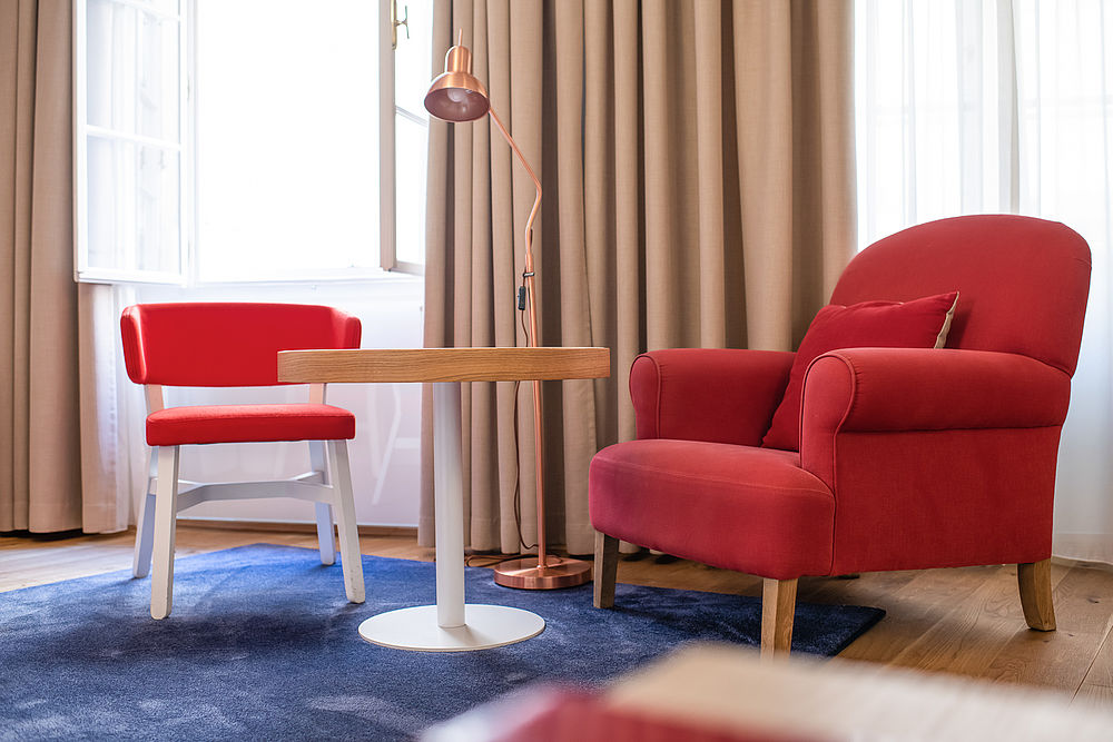 Roter, großer Sessel und passender Stuhl dazu in der Juniorsuite im romantischen Hotel Salzburg