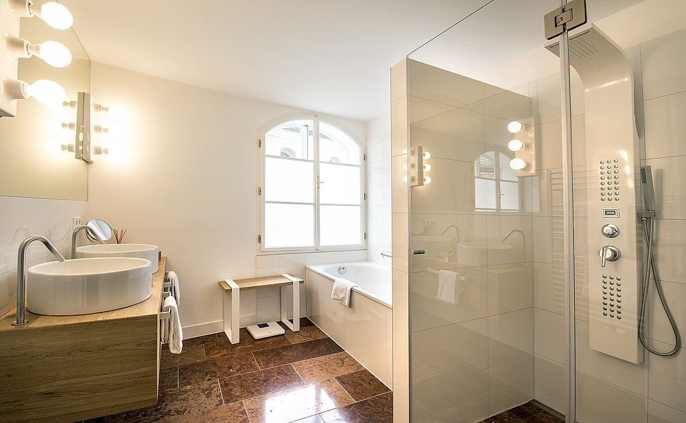 Großräumiges Badezimmer in der Roof Top Suite "Jedermann" mit Regendusche und zwei Waschbecken im Boutique Hotel Salzburg