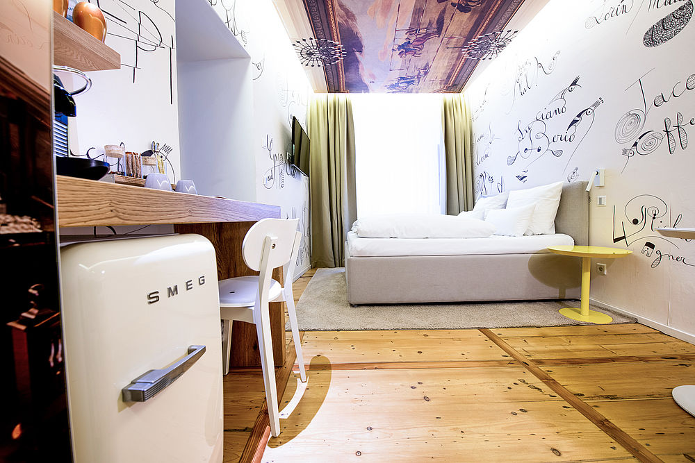 Blick von der Seite auf das Doppelbett im romantischen Hotel Salzburg