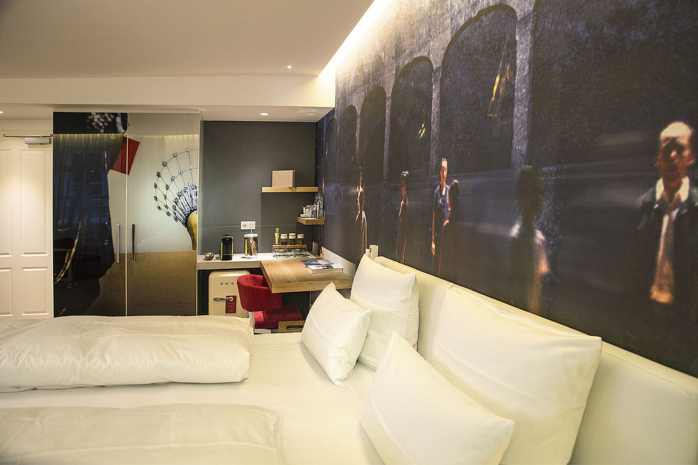 Blick von der Seite auf das Bett der Juniorsuite im romantischen Hotel Salzburg